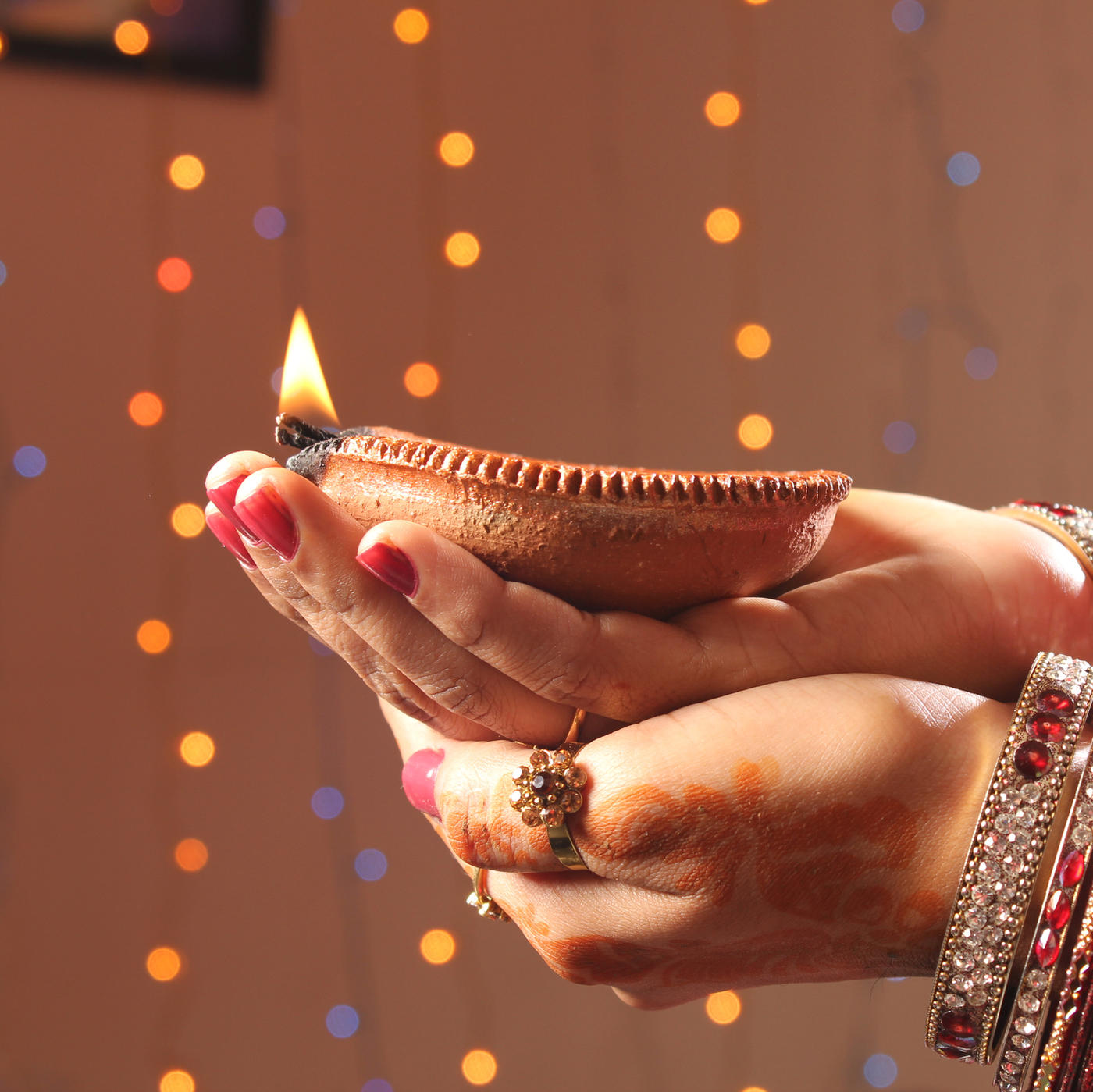 Hands holding a candle for Diwali